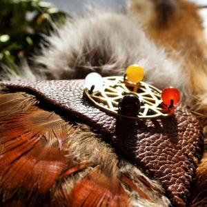 Detailaufnahme Medizinrad mit farbigen Steinen am Ledergriff des Räucherfächers