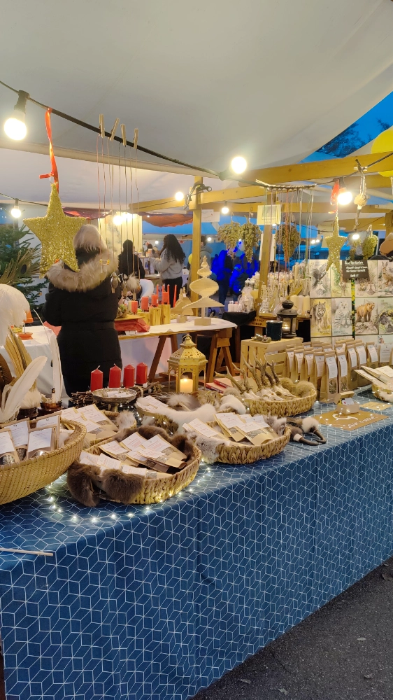 Weihnachtlich geschmückter Marktstand mit regionalen Kräuterprodukten und Handwerk